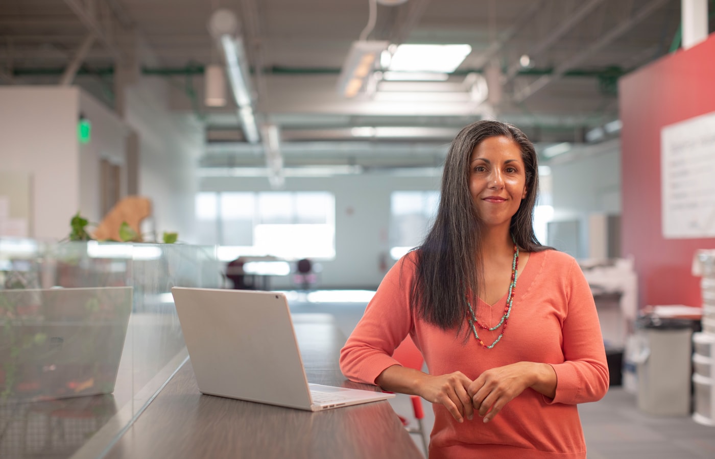 Placeholder photograph of a bookkeeper working at a laptop in an open plan office
