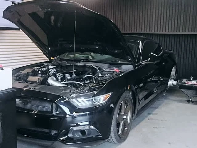 A black Mustang in the Downlow workshop with the bonnet up