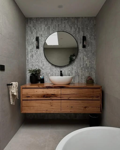 Ensuite with a grey stone mosaic feature wall and timber vanity, tiled by Greyscale Tiling
