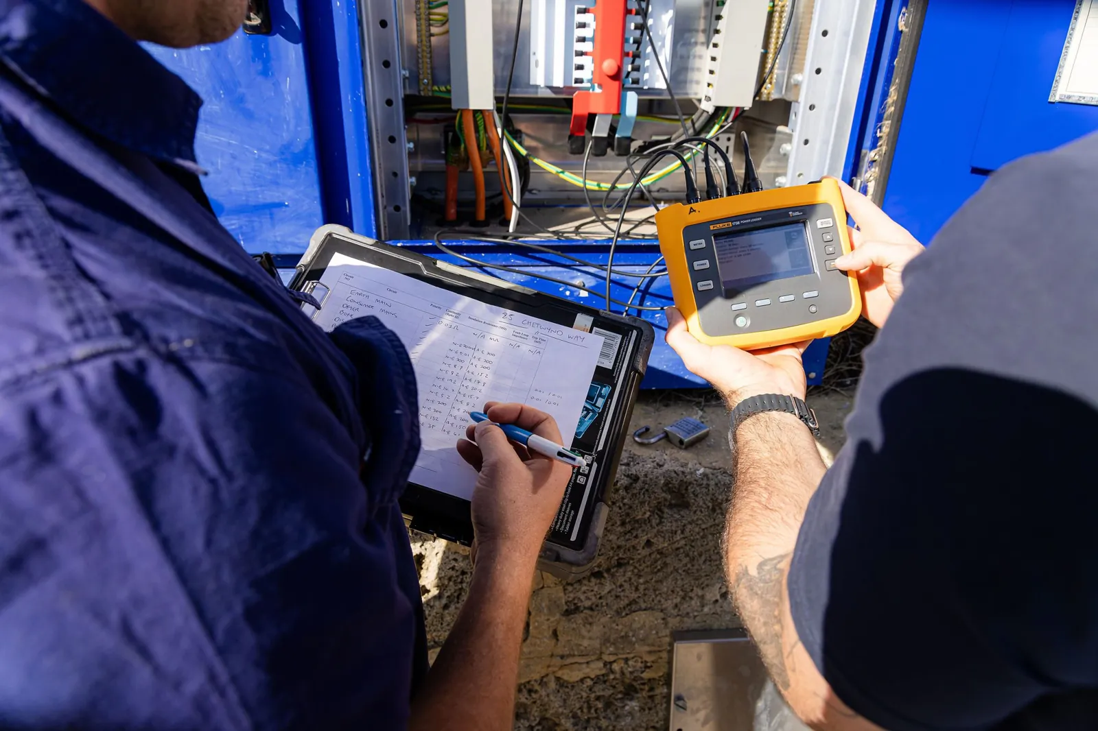 Two electricians testing a commercial installation