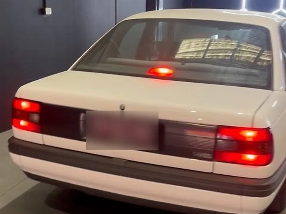 A white classic sedan in the HazTech workshop