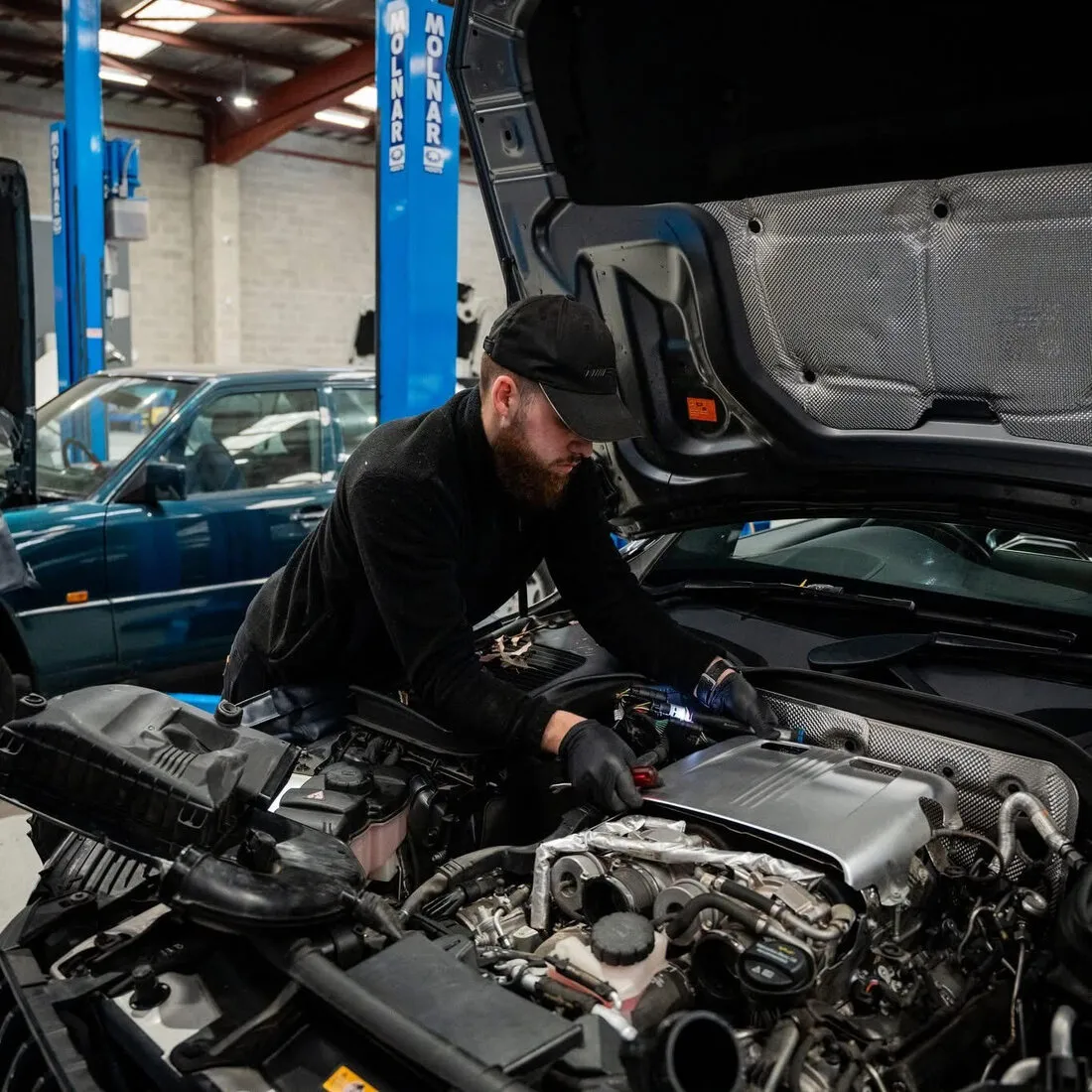 Ricky working under the bonnet of a Mercedes