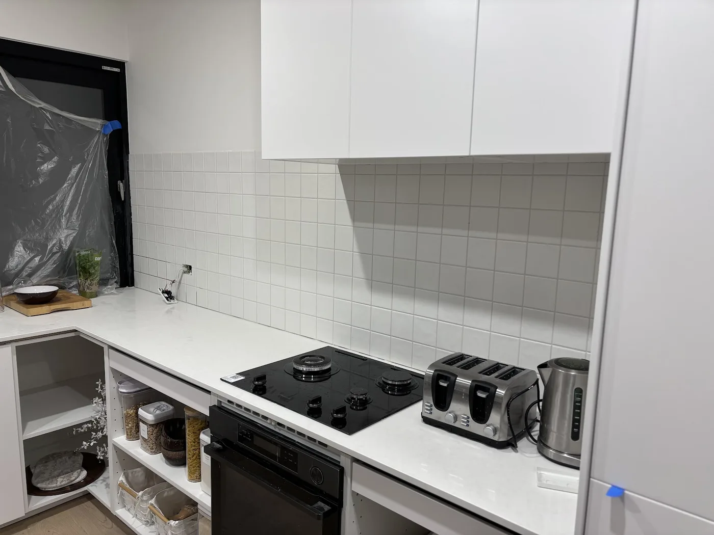 A white kitchen splashback behind a cooktop