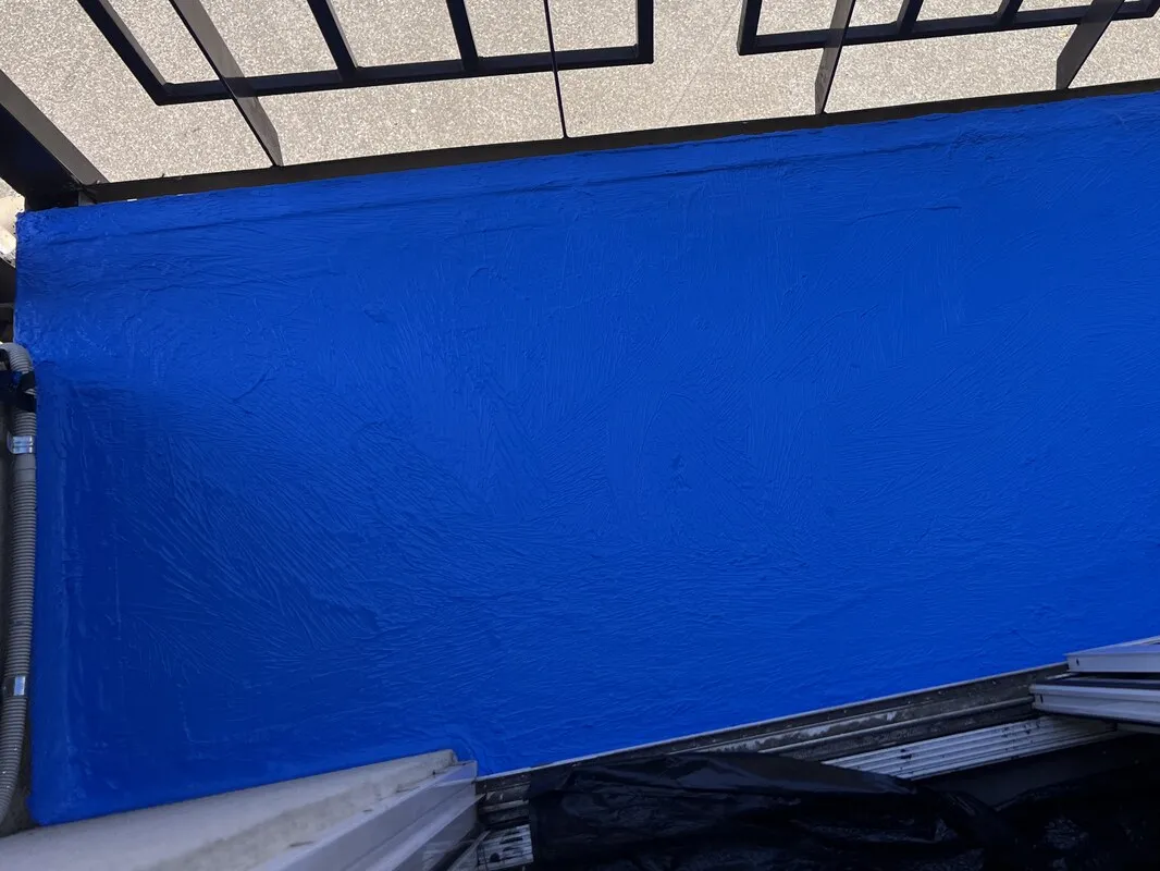 Blue waterproofing membrane applied across a balcony floor