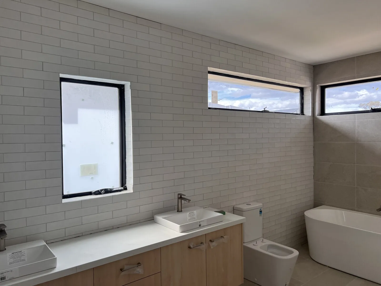A new bathroom with white subway wall tiles and a freestanding bath