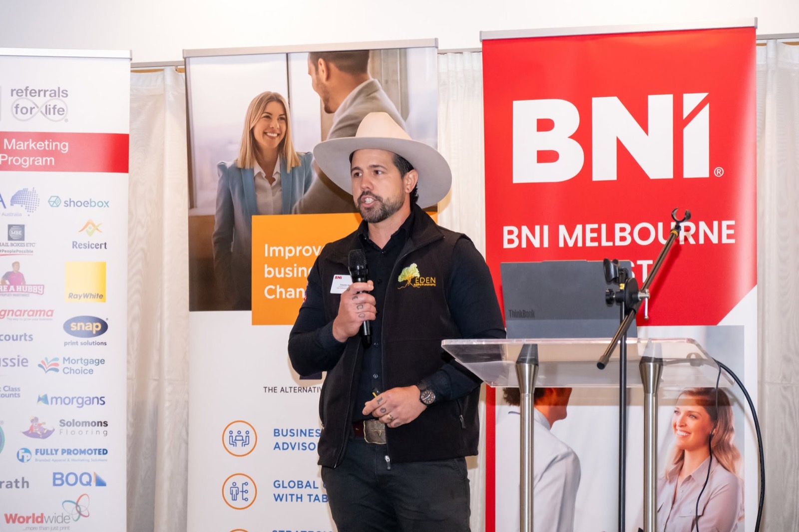 Eduardo from Eden Building & Landscaping presenting at the podium at a BNI Melbourne event