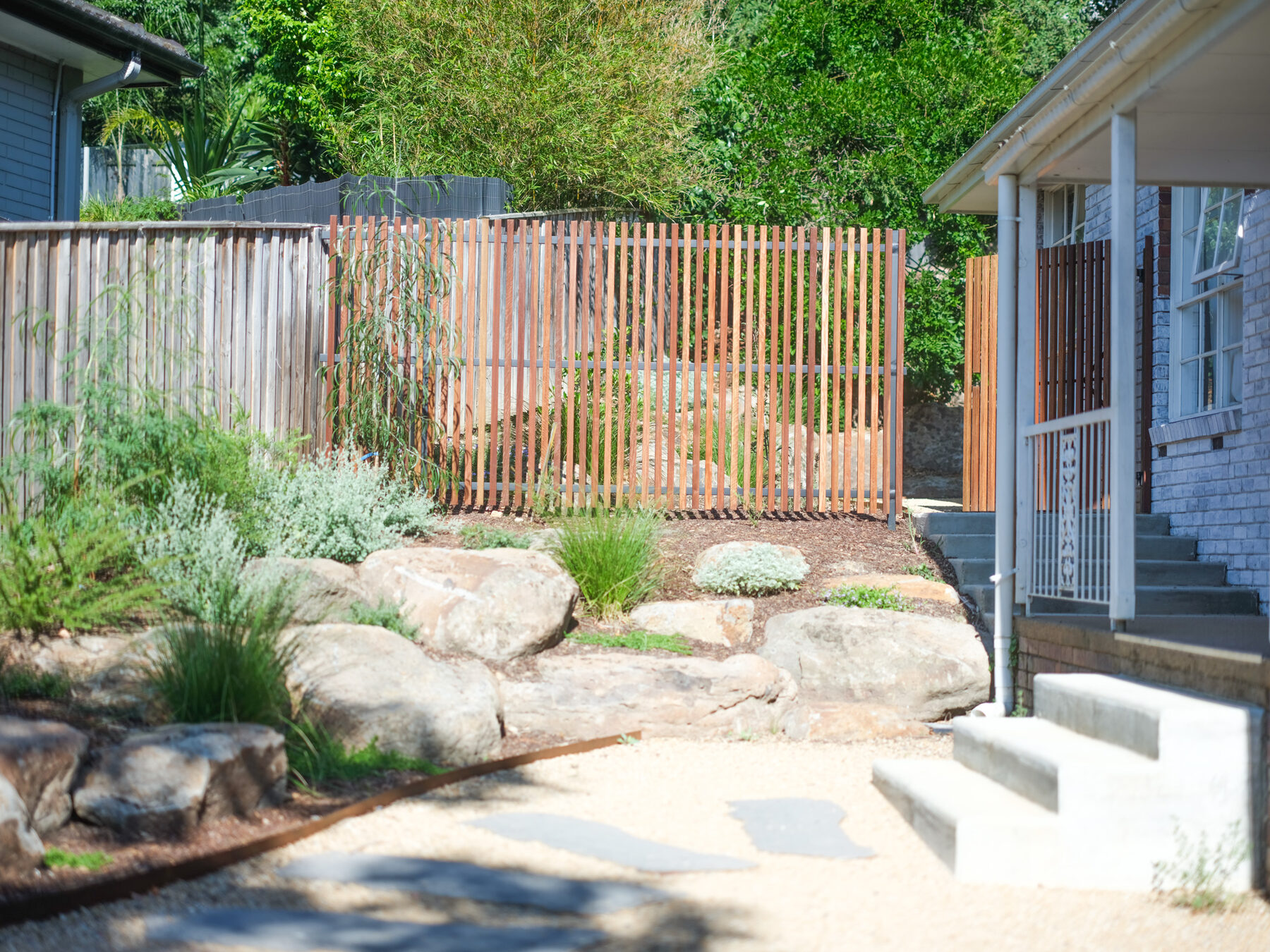 Gravel courtyard with stepping stones and a rock wall in Melbourne