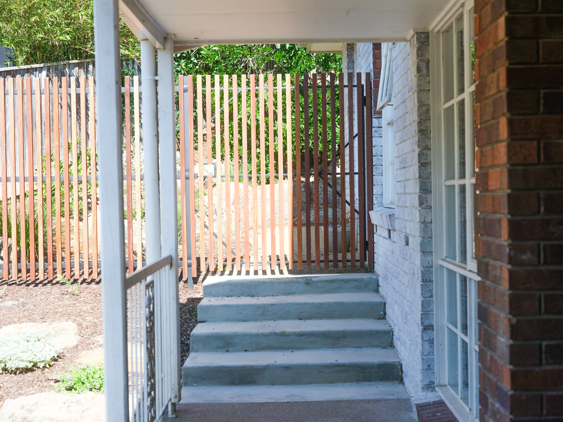 Hardwood slat gate and screen leading to concrete steps