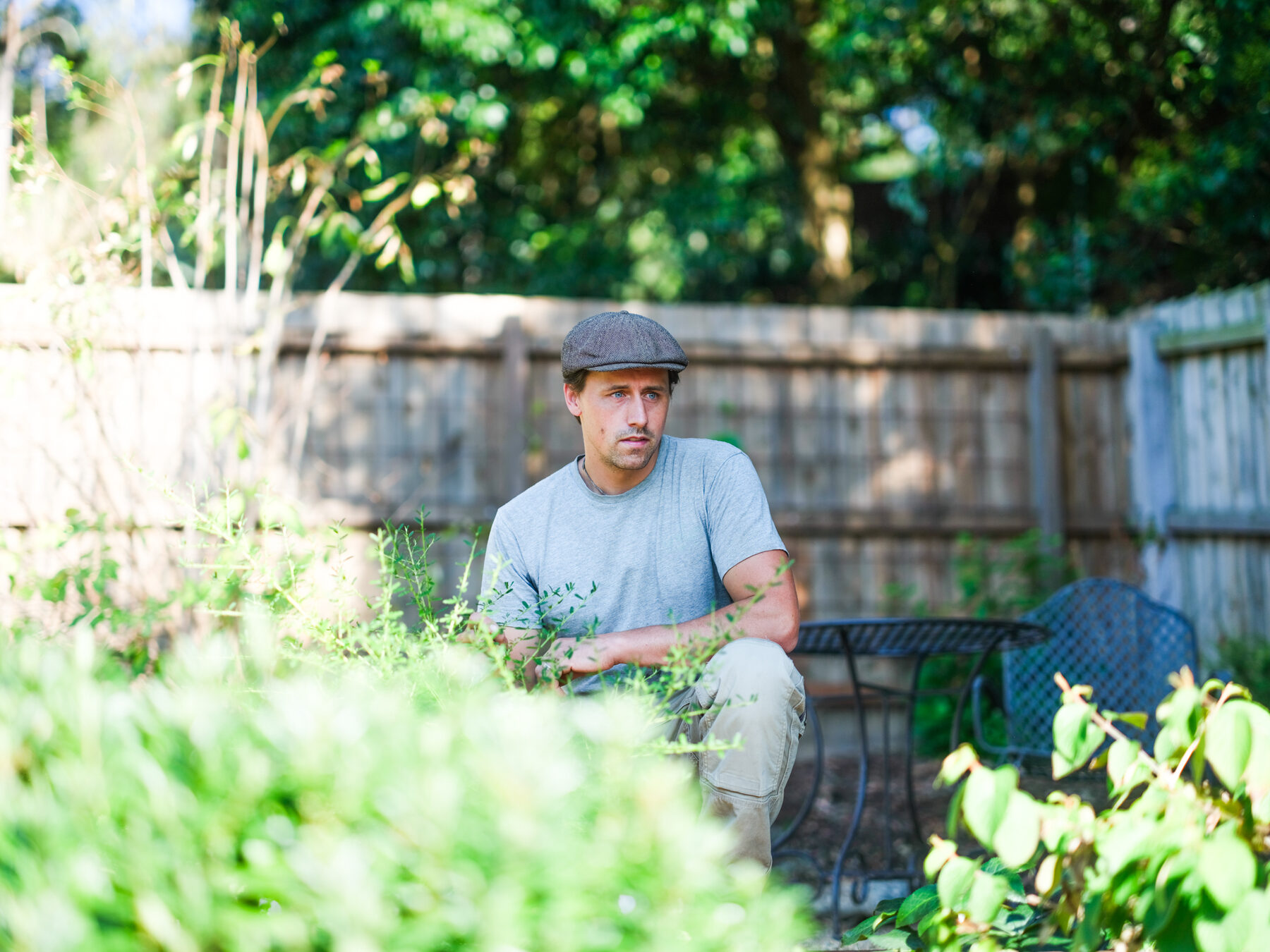 Ollie Macindoe kneeling in a planted garden