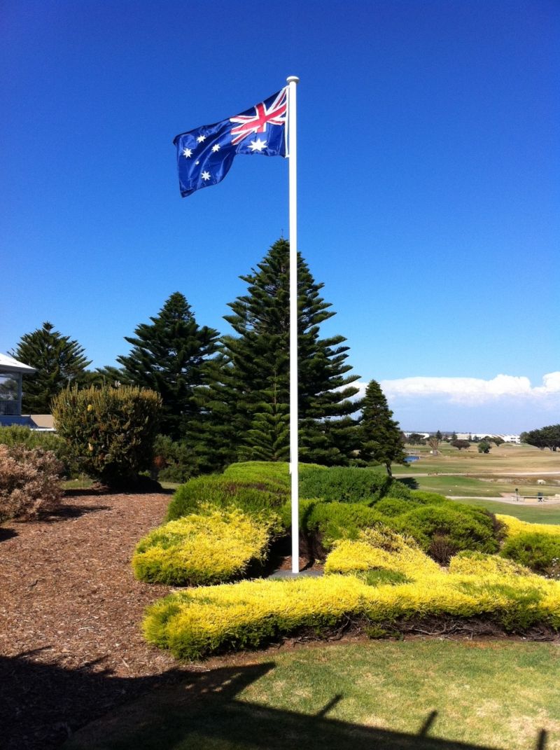 Australian flag flying on a white Garden Master flagpole in a coastal garden