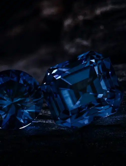 Two blue Ceylon sapphires photographed on dark stone