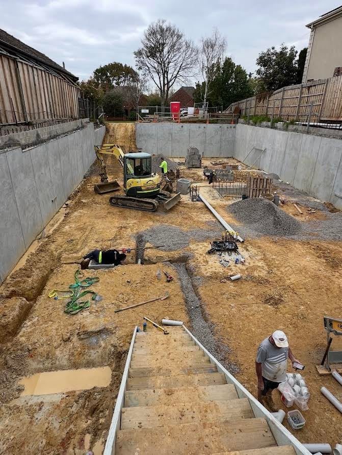 Shotcrete walls, soldier piles and timber lagging holding the ground back while the basement goes in.