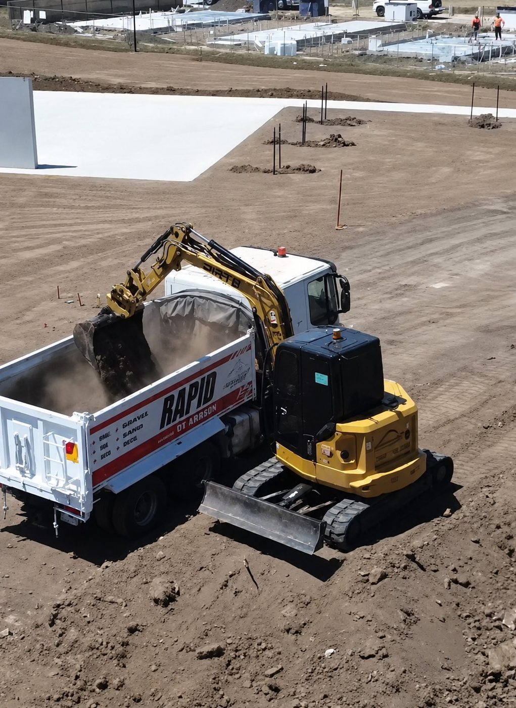 Spoil going straight into the truck, which is what keeps a small site moving.