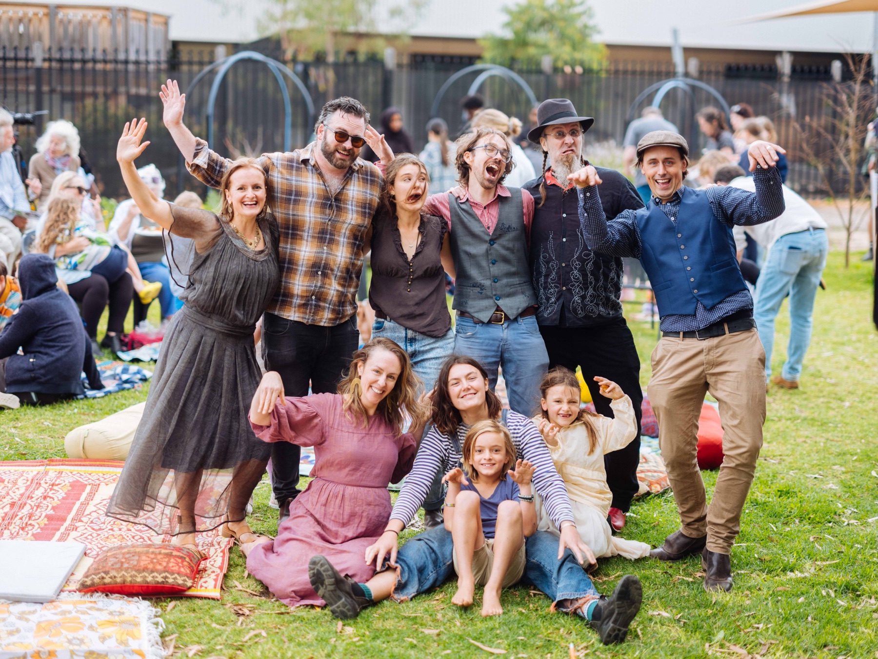 The Little Sirens musicians and families posing together on the grass