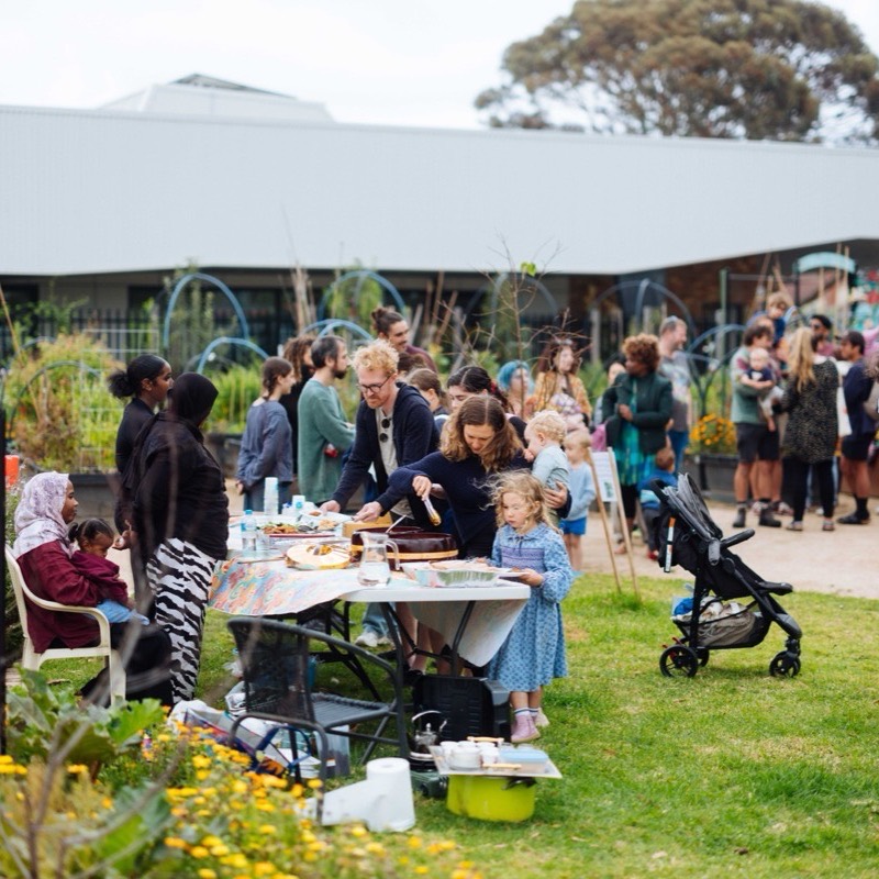 A wide view of the whole garden during the concert, with families spread across the lawn