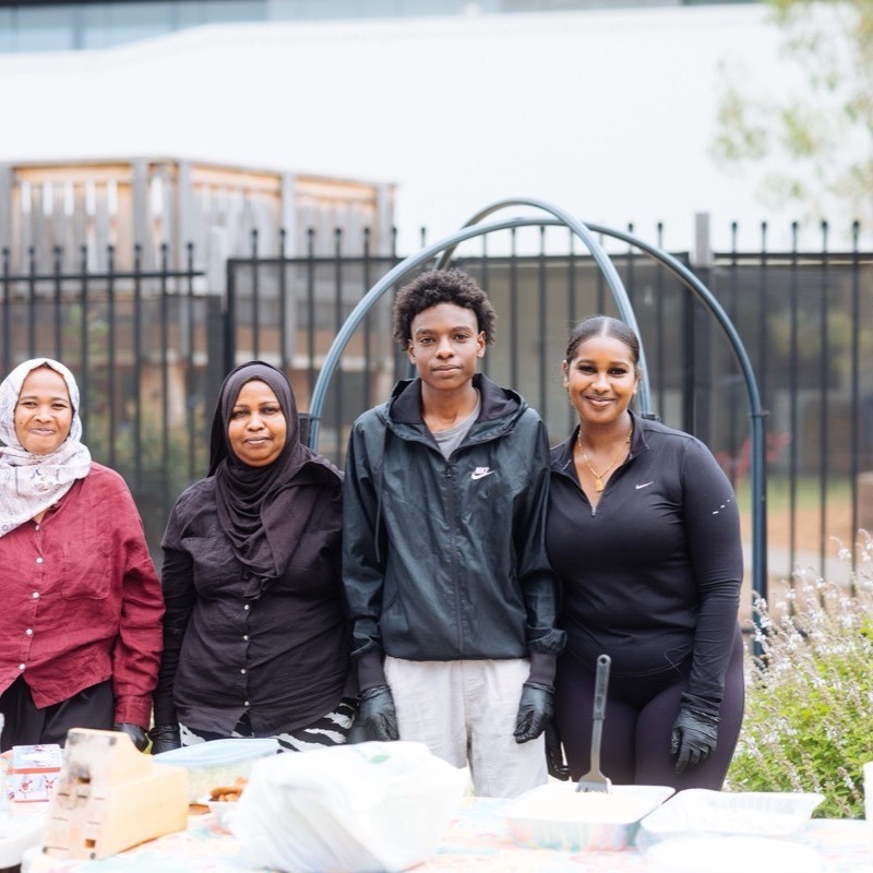 Four women standing behind the food table they set up for the shared lunch