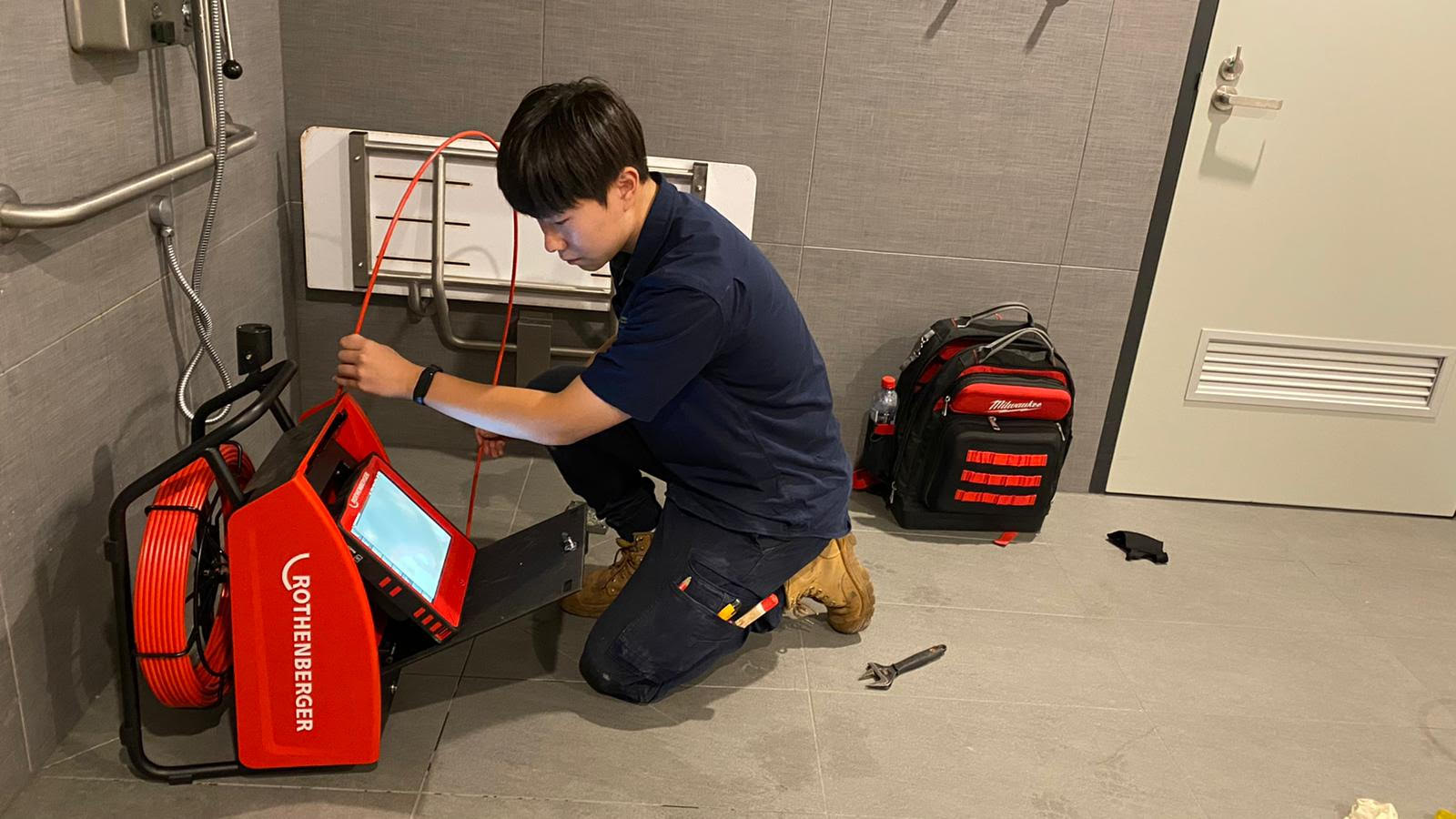 A Plumbing Possibilities technician working on site with drain clearing equipment