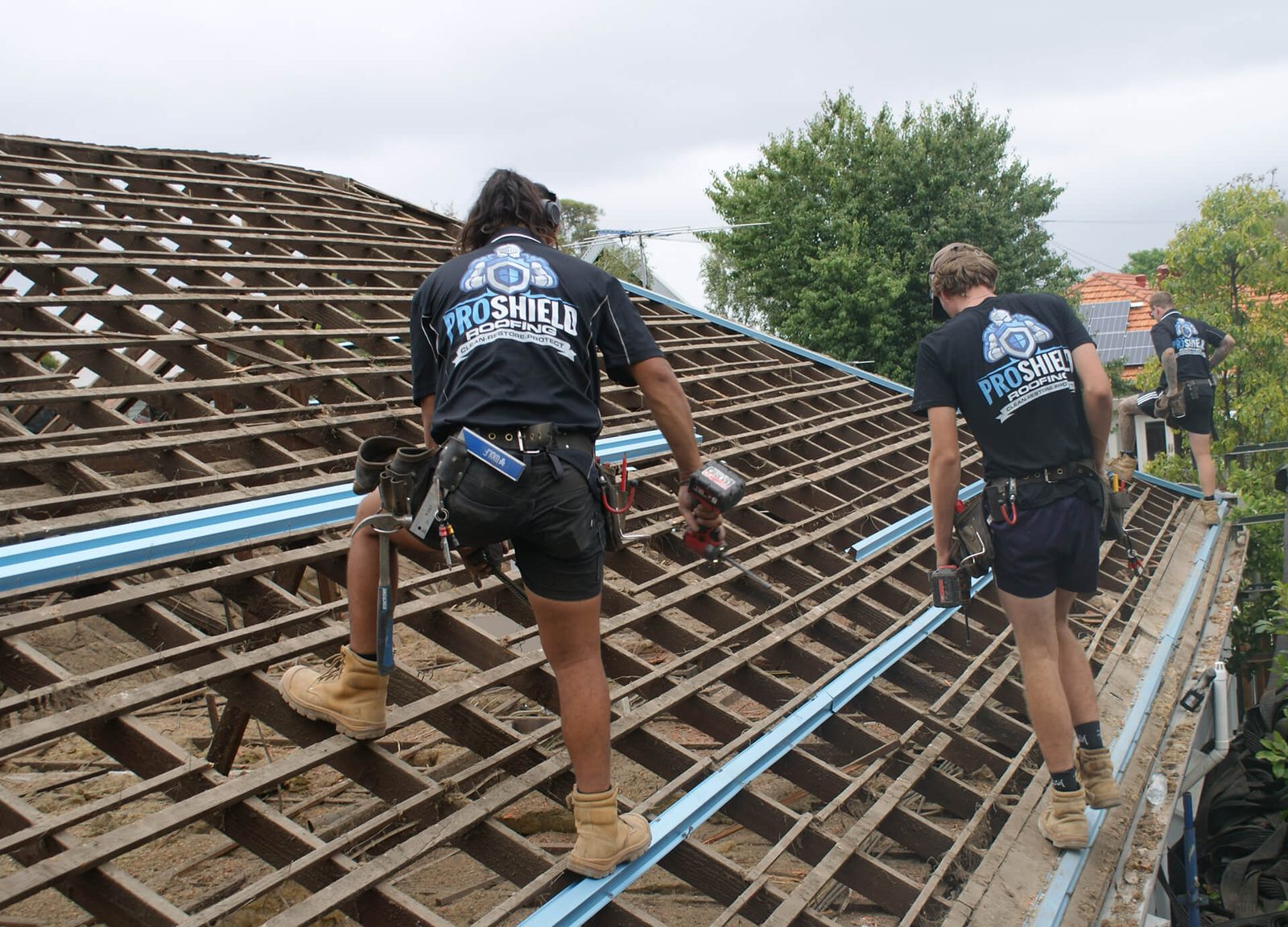 Pro Shield roofers stripping an old tile roof back to the battens