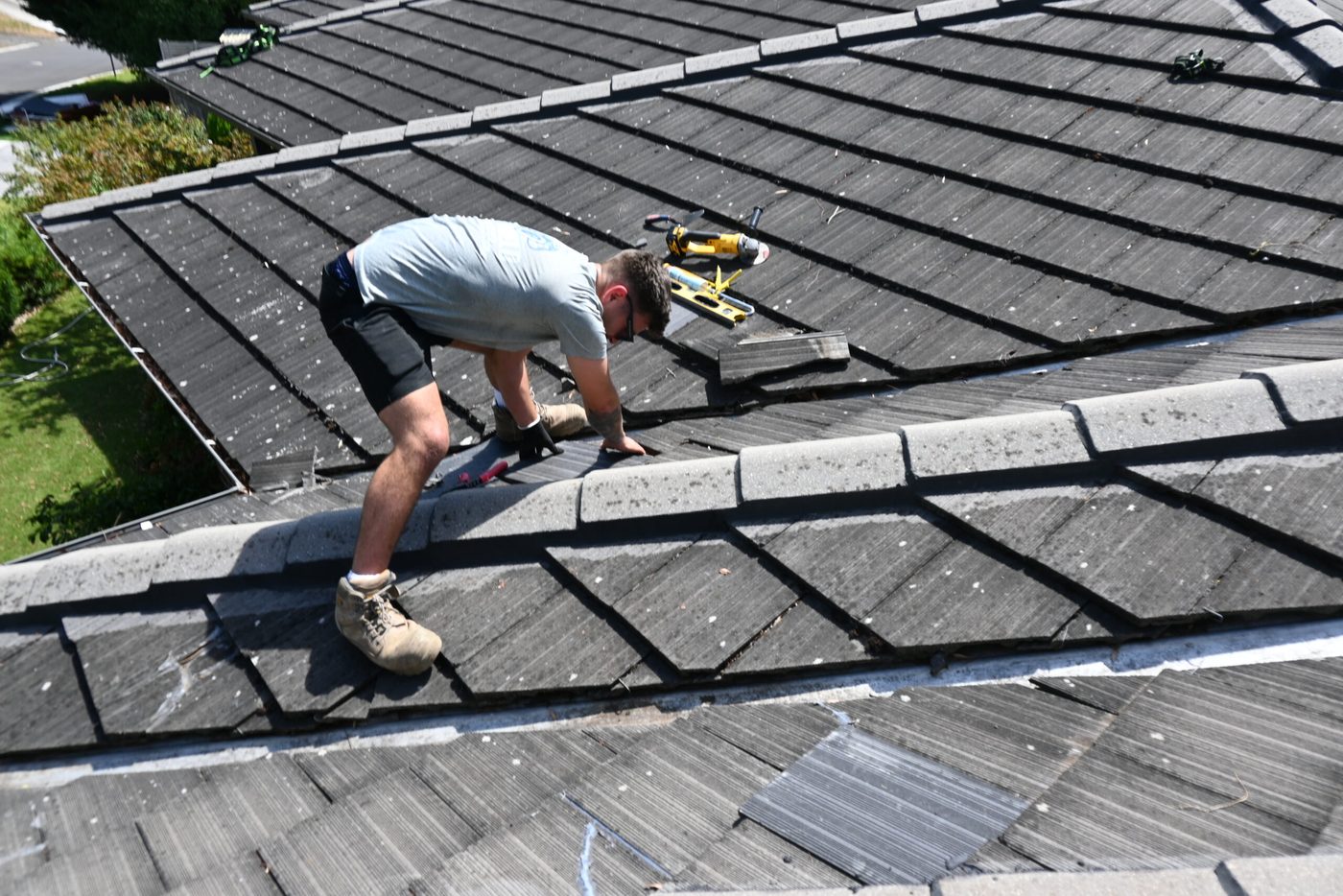 A Pro Shield roofer repointing ridge capping on a tile roof