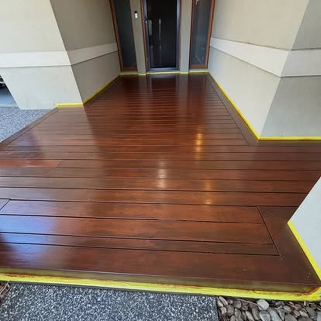 Freshly finished timber floor with masking tape still at the edges