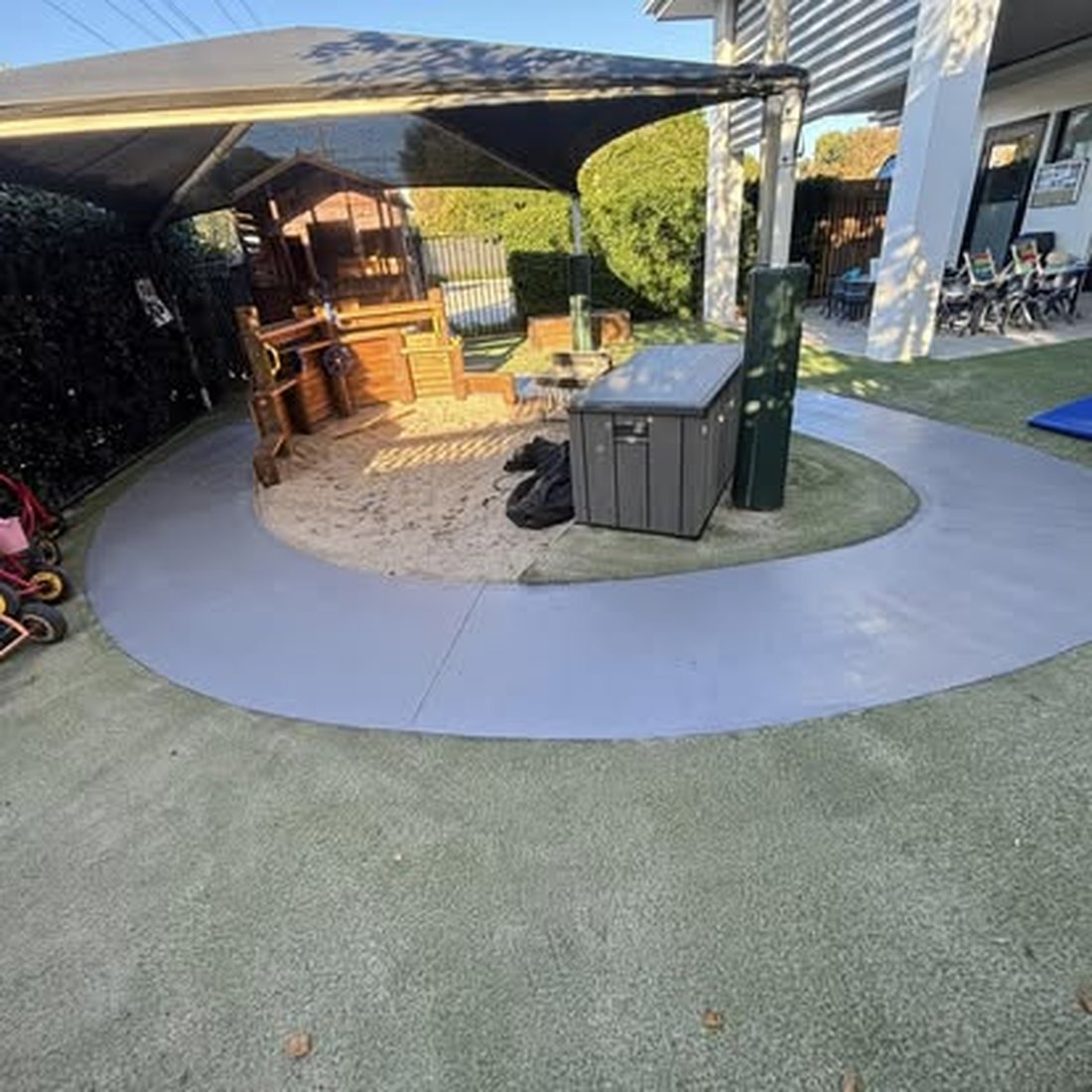 Circular paved patio with a curved timber bench around a fire pit