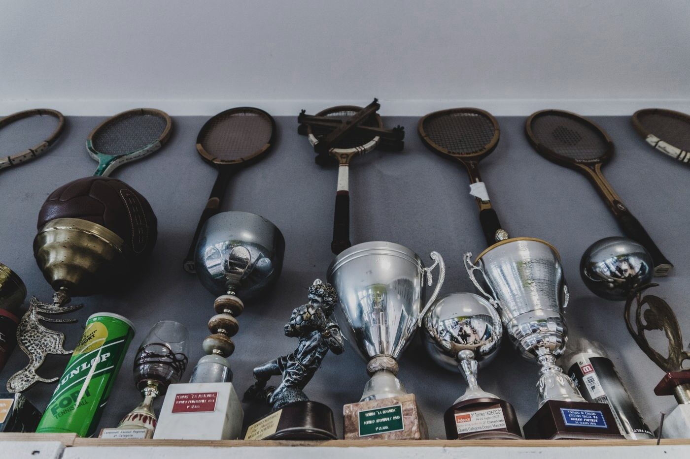 A shelf of trophies and racquets